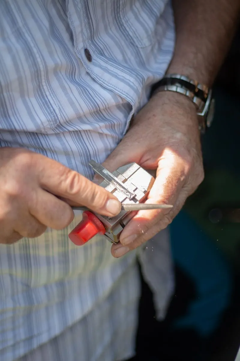 Manos de un cerrajero ajustando una llave con una herramienta de precisión