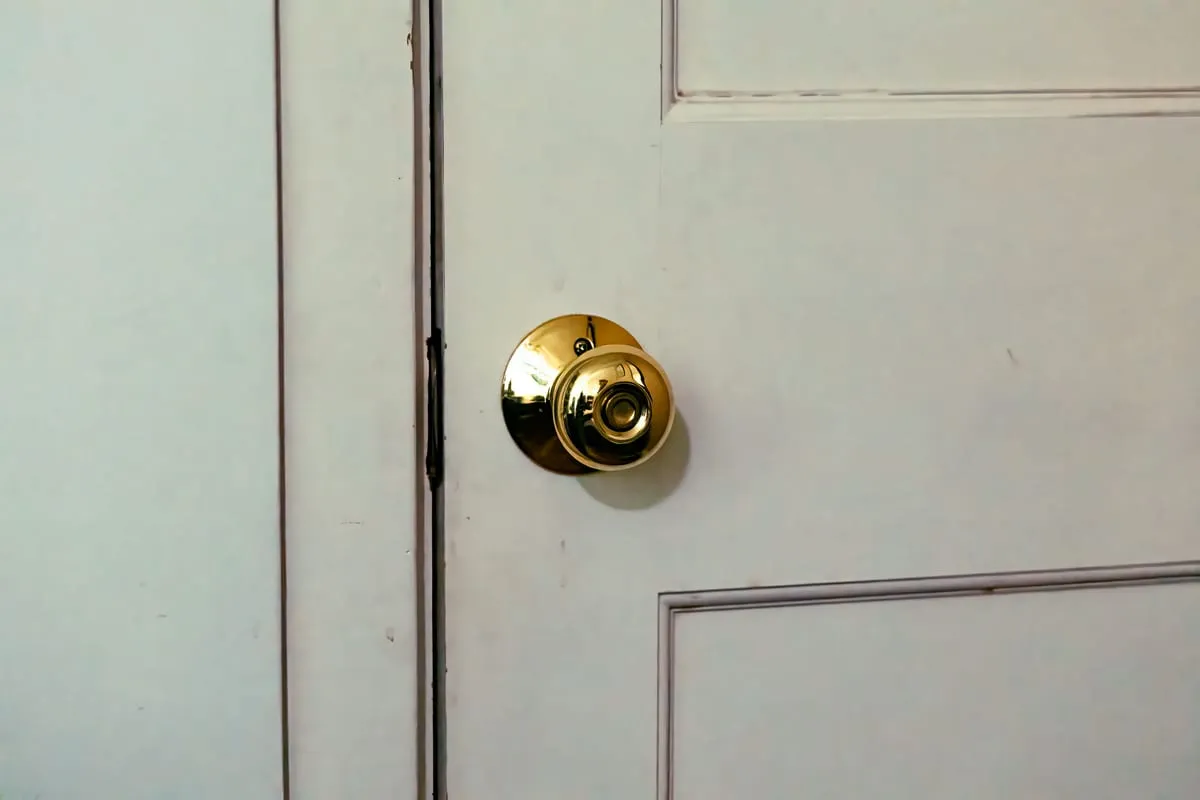 Llavín de pomo dorado instalado en una puerta blanca